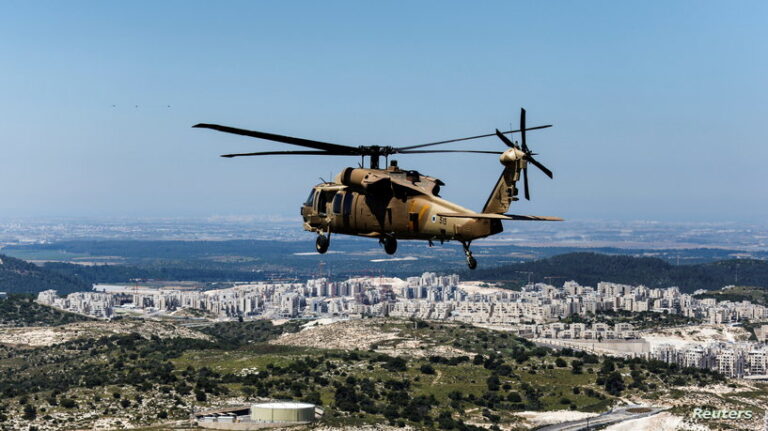 An aerial view shows an Israeli Black Hawk helicopter flying over the the Israeli settlement of Beitar Illit