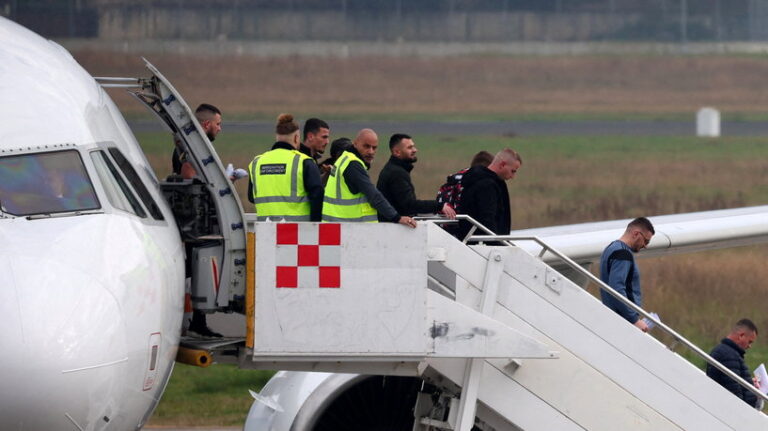British Immigration Enforcement officers work as an airplane with immigrants deported from England arrives at Tirana International Airport