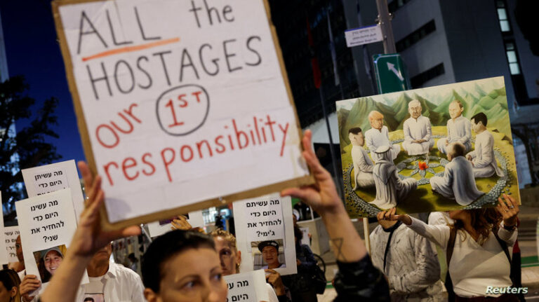 Israeli youth prepare an art installation of teddy bears with pictures of hostages, in Tel Aviv
