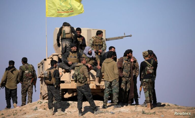 Members of Syrian Democratic Forces (SDF) stand together near Baghouz, Deir Al Zor province