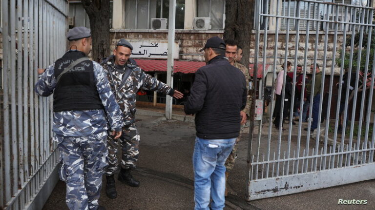 A Lebanese police gestures as he stands outside Justice Palace in Beirut