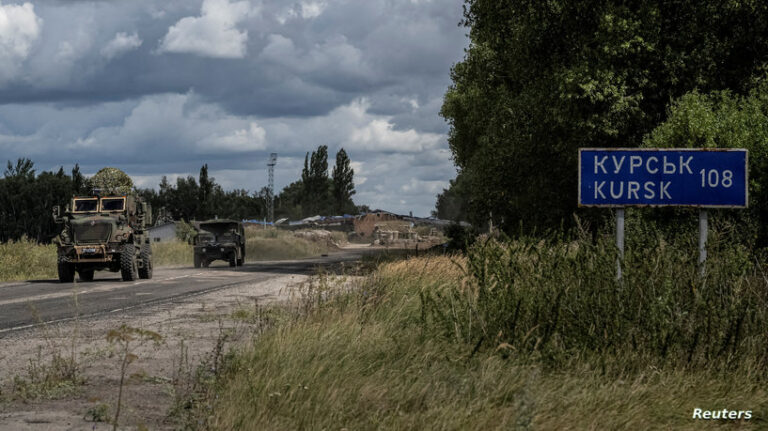 FILE PHOTO: Ukrainian servicemen ride military vehicles from a crossing point at the border with Russia in Sumy region