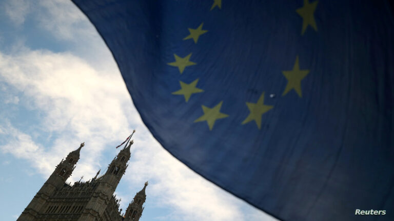 FILE PHOTO: An EU flag flutters during an anti-Brexit demonstration outside the Houses of Parliament in London
